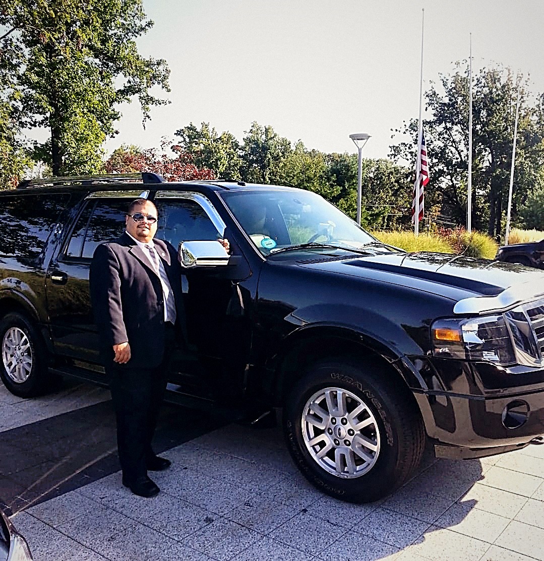 Luis Resto standing beside his black Ford Expedition, ready for a pickup